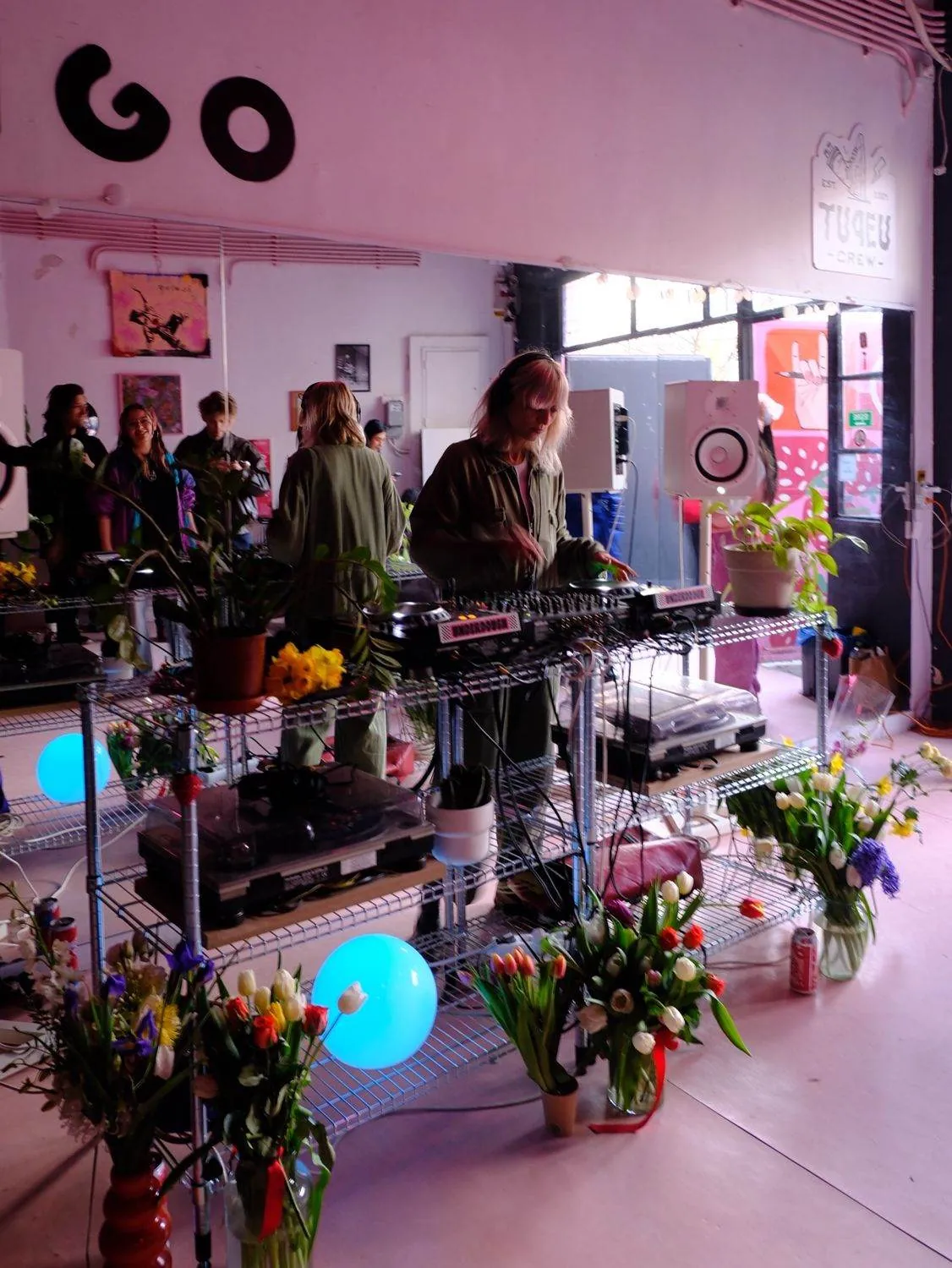 DJ la pupitru, înconjurat de flori și plante